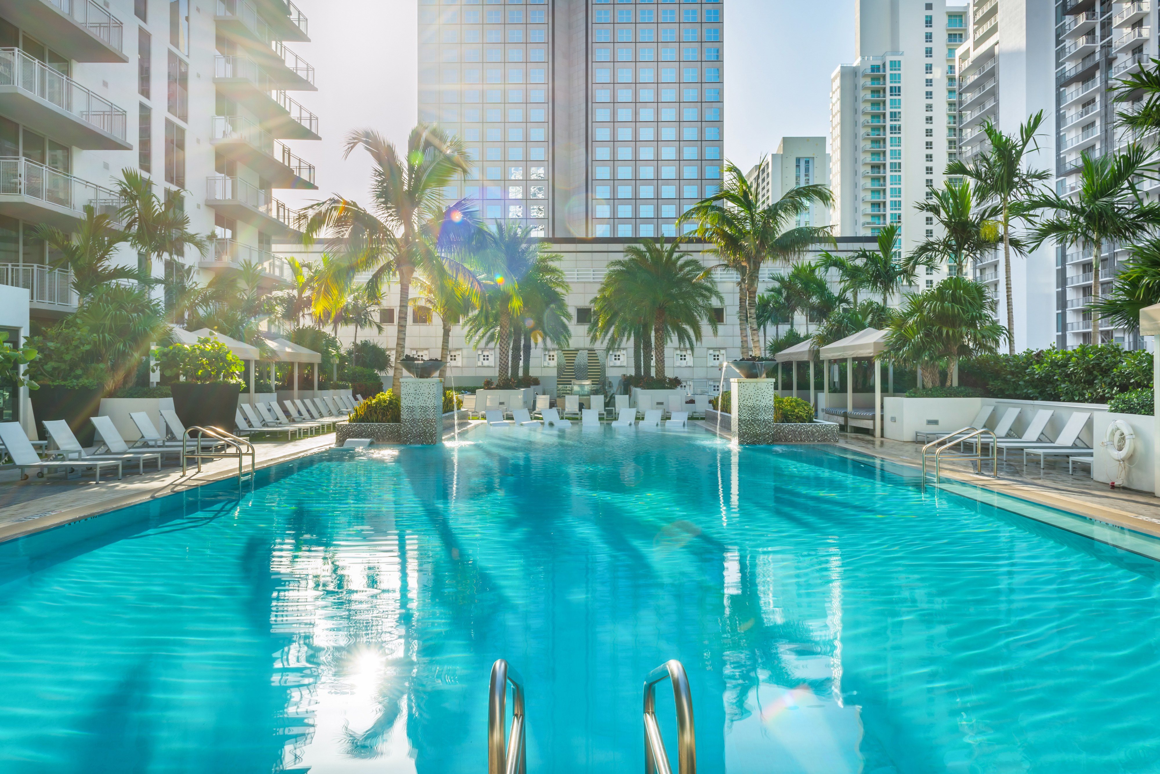 A large swimming pool with sunlight reflecting on the water.